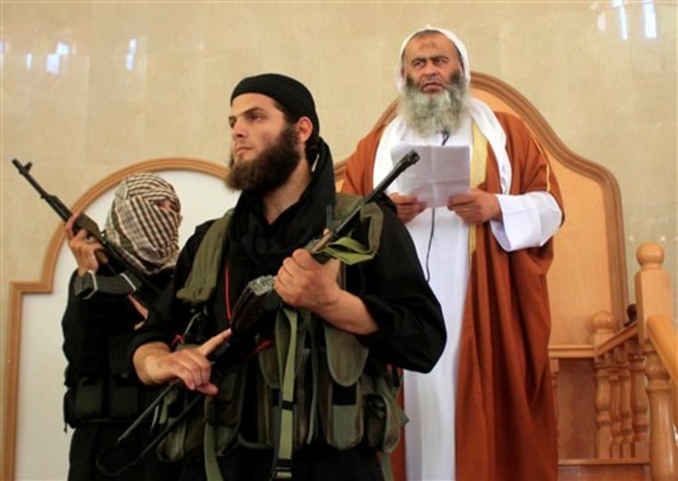 Members of a militant Islamic group Jund Ansar Allah, one of several al-Qaida-inspired groups operating in the Gaza Strip, stand guard as their leader Abdel-Latif Moussa, right, speaks during Friday prayers in Rafah, southern Gaza Strip, in 2009. Palestinian militants inspired by al-Qaida posted a Hebrew-language threat on an extremist web site Thursday, vowing revenge for the deaths of two Gaza militants in an Israeli air strike.